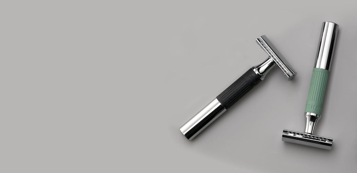 Two MUHLE NEO safety razors on a neutral gray background, one with a black handle and one with a mint green handle, both featuring chrome safety razor heads.